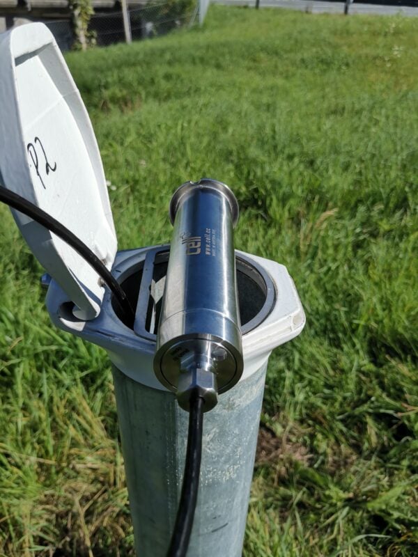 cell Datenlogger vom Typ nivelo zur Grundwasserüberwachung installiert in geöffneter Messstelle auf einer Wiese.